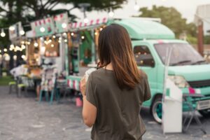 Young asian woman walking in the food truck market