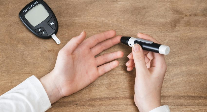 Diabetes checking blood sugar level. Child using lancelet and glucometer