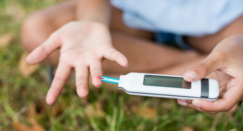 Girl testing diabetes on glucose meter