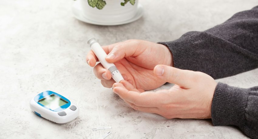 man hands using lancet on finger to check blood sugar ketones level glucose meter. medicine diabetes