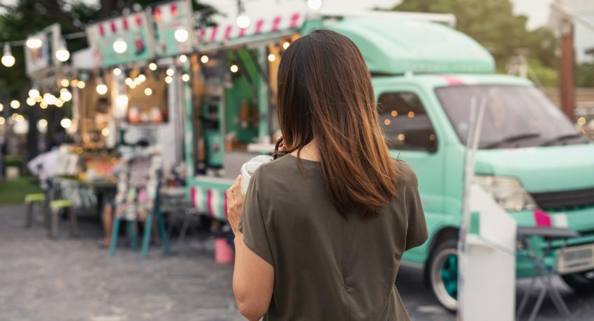 Young asian woman walking in the food truck market